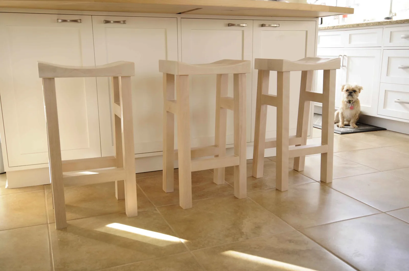Three whitewashed birch stools at a kitchen island