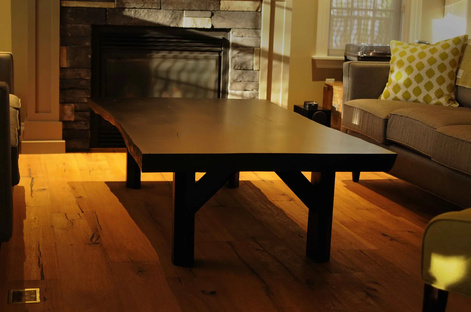 Low slab coffee table with a dark finish and trestle legs in a living room