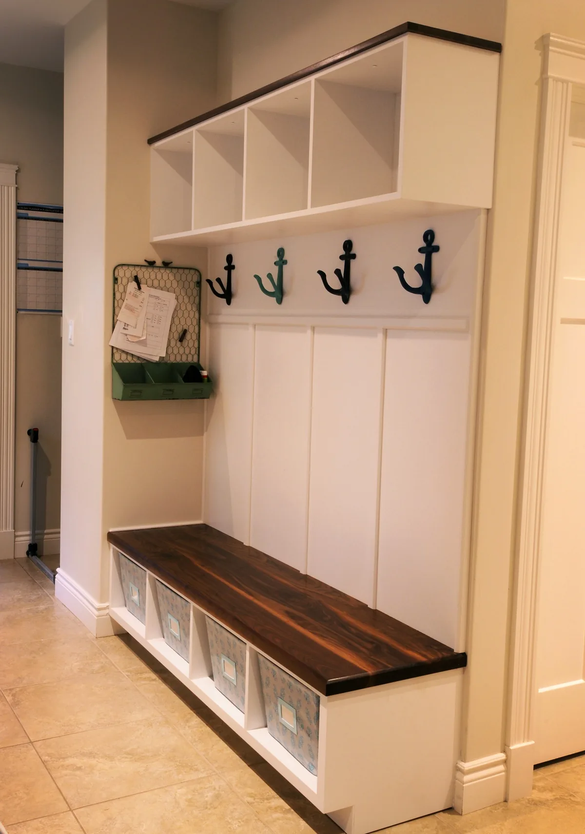 Tall laundry room lockers with a bench and coat hooks