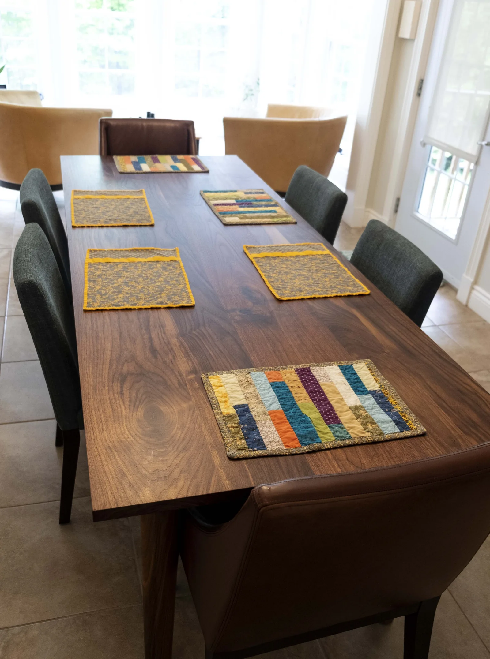 Eight-foot walnut dining table set with placemats in a dining room