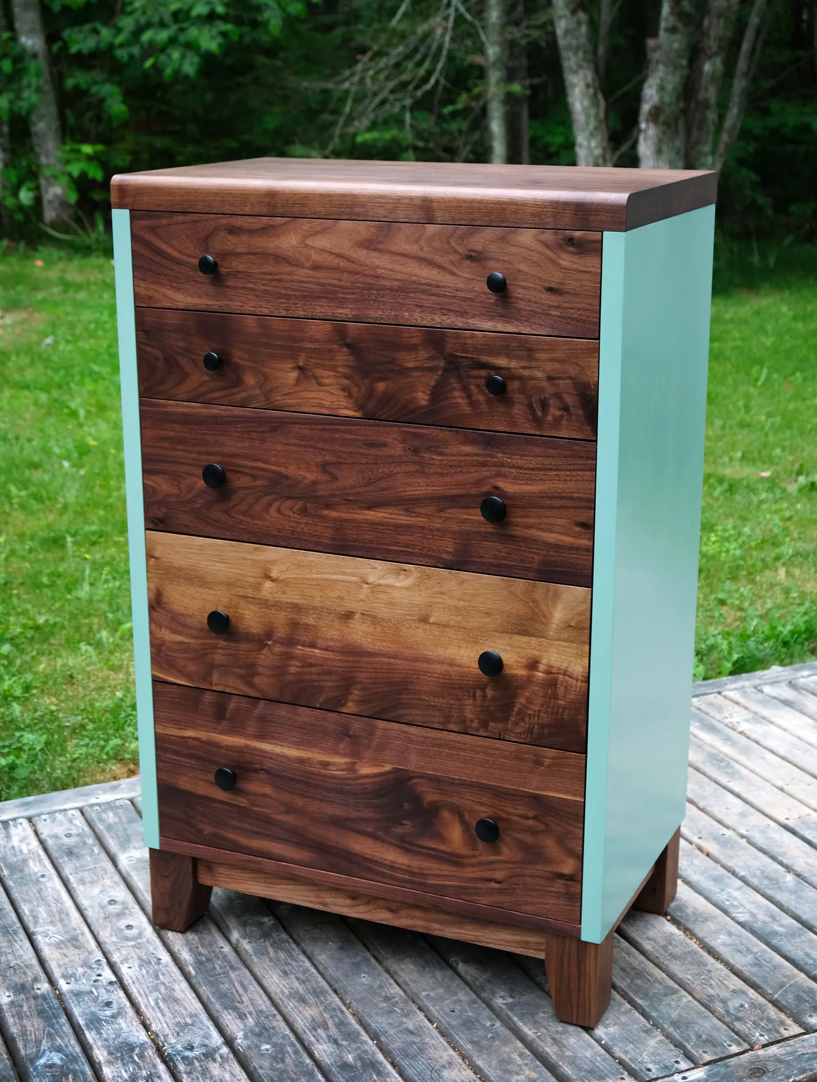 Tall walnut dresser with painted sides on a deck