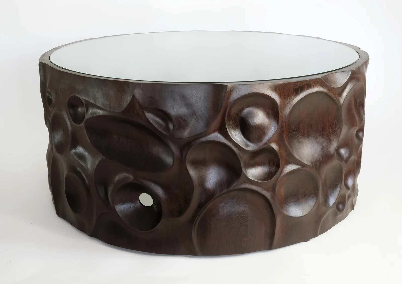 Round wenge coffee table with a carved outer wall and an inset glass top
